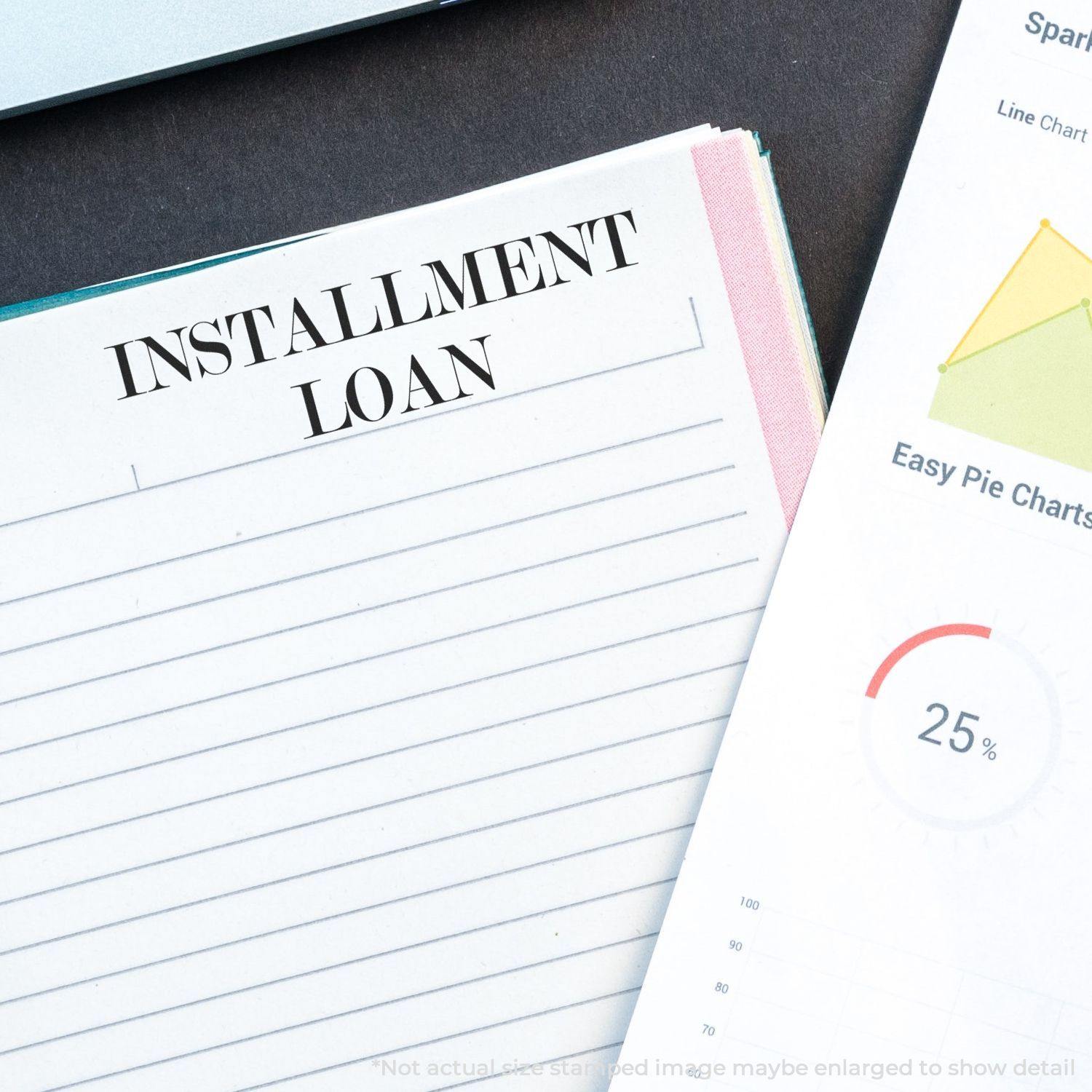 Installment Loan Rubber Stamp used on a lined paper next to a financial chart, emphasizing loan documentation and financial planning.