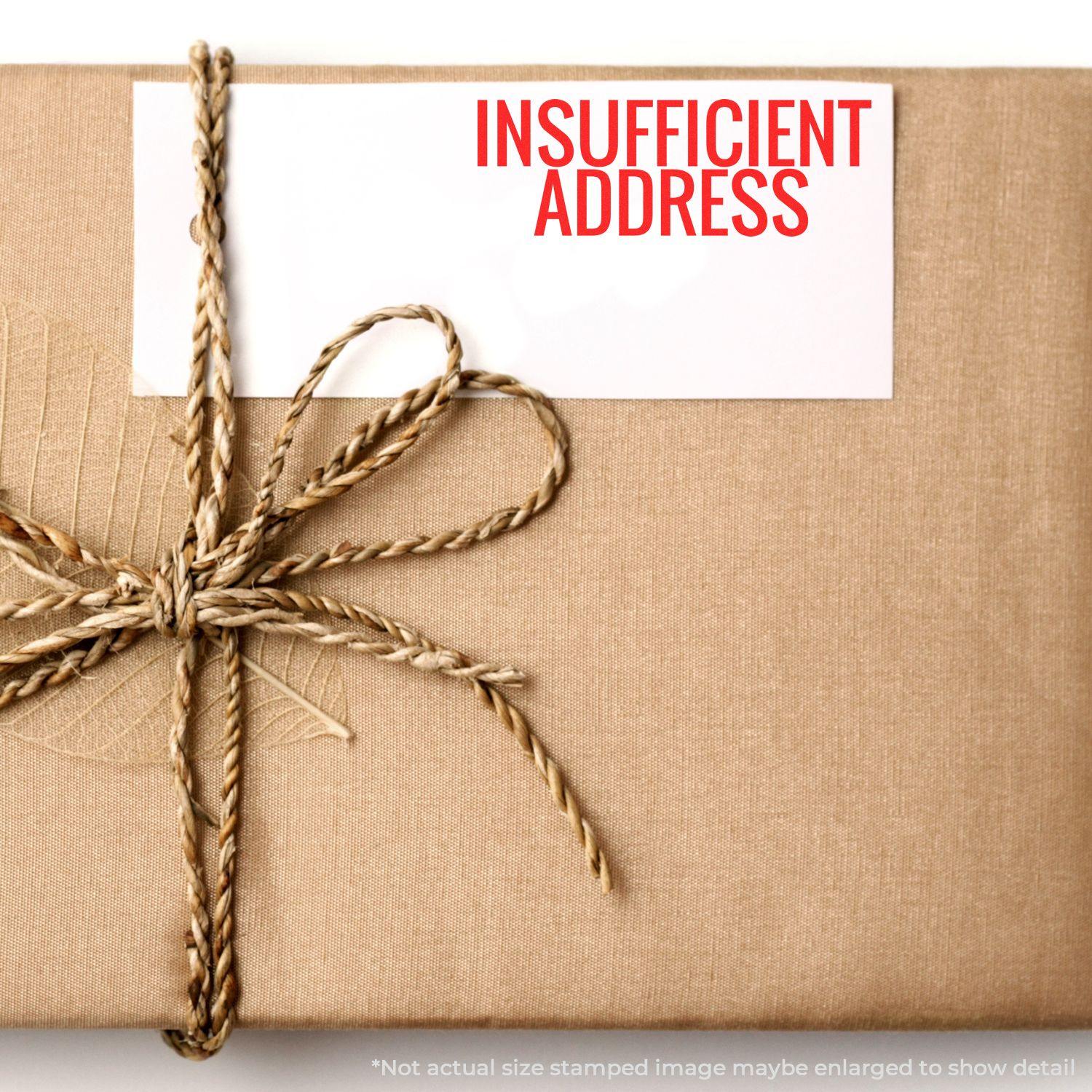 A brown package with a card stamped INSUFFICIENT ADDRESS using the Self Inking Insufficient Address Stamp, tied with a twine bow.