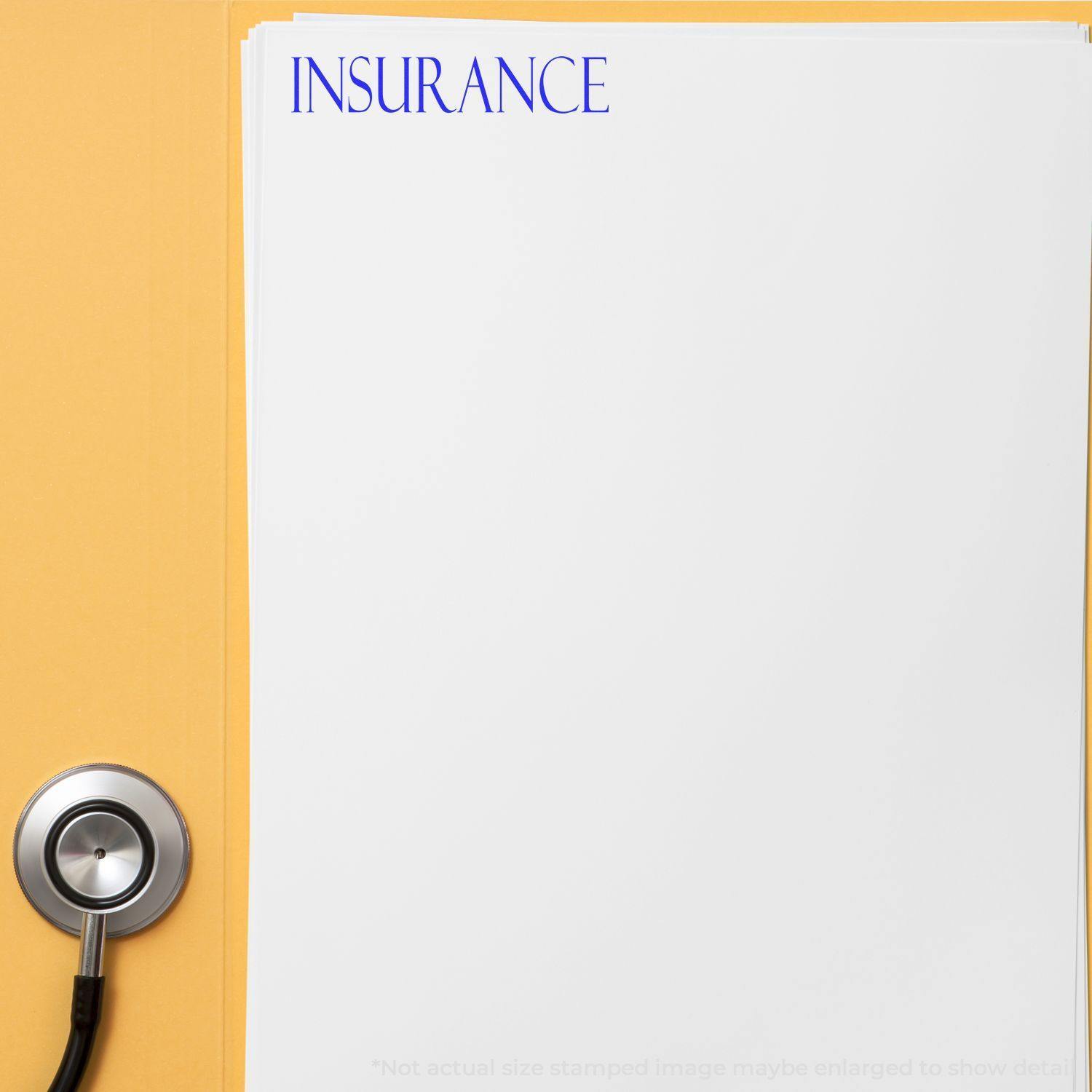 A Large Pre-Inked Insurance Stamp marks INSURANCE in blue ink on a white document, with a stethoscope placed beside it on a yellow surface.