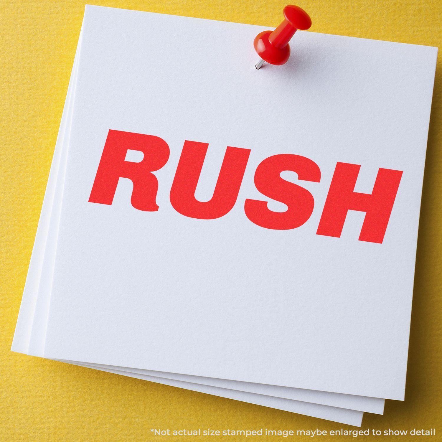 Slim Pre-Inked Italic Rush Stamp imprint in bold red letters on white paper, pinned to a yellow background with a red pushpin.