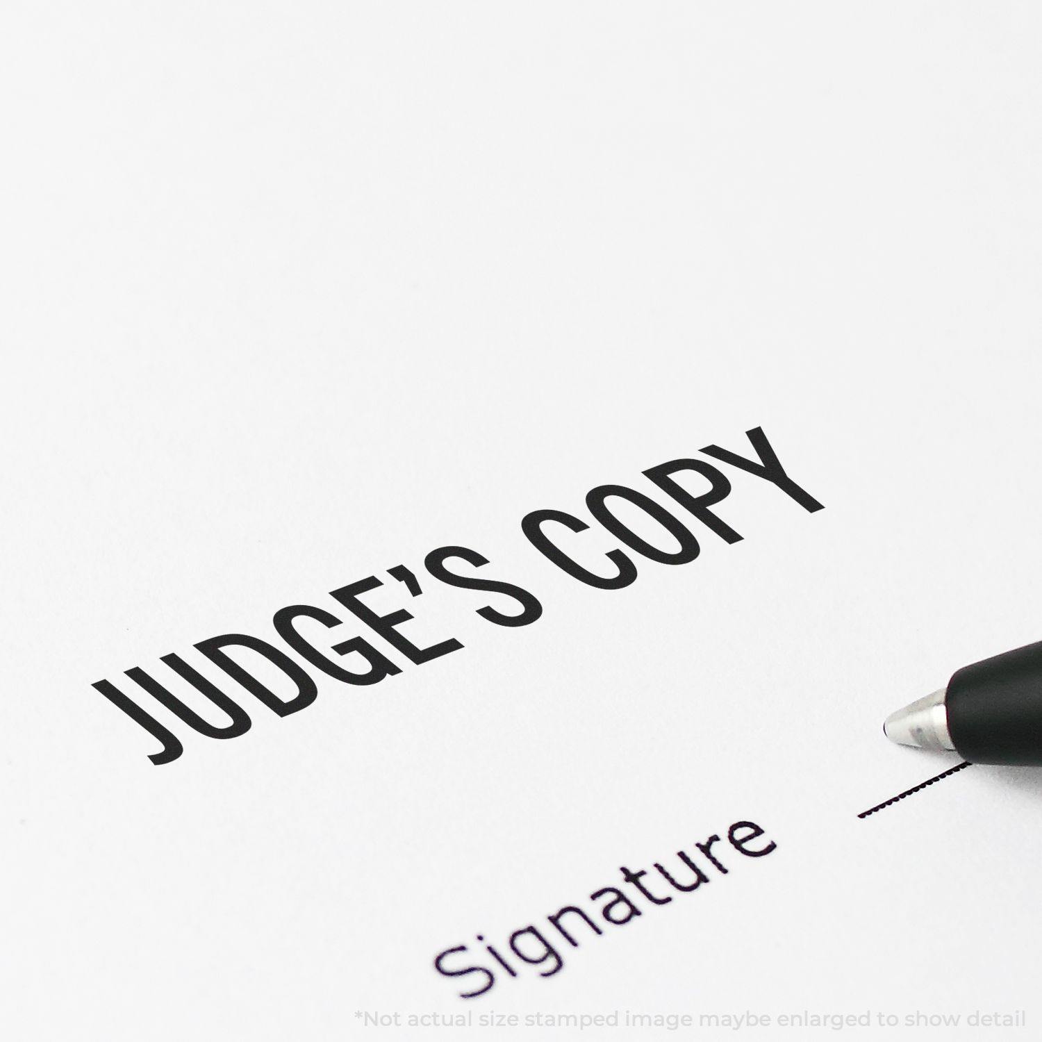 Judge's Copy Rubber Stamp imprint on paper near a pen, with the text 'Signature' below. Note: Not actual size stamped image.