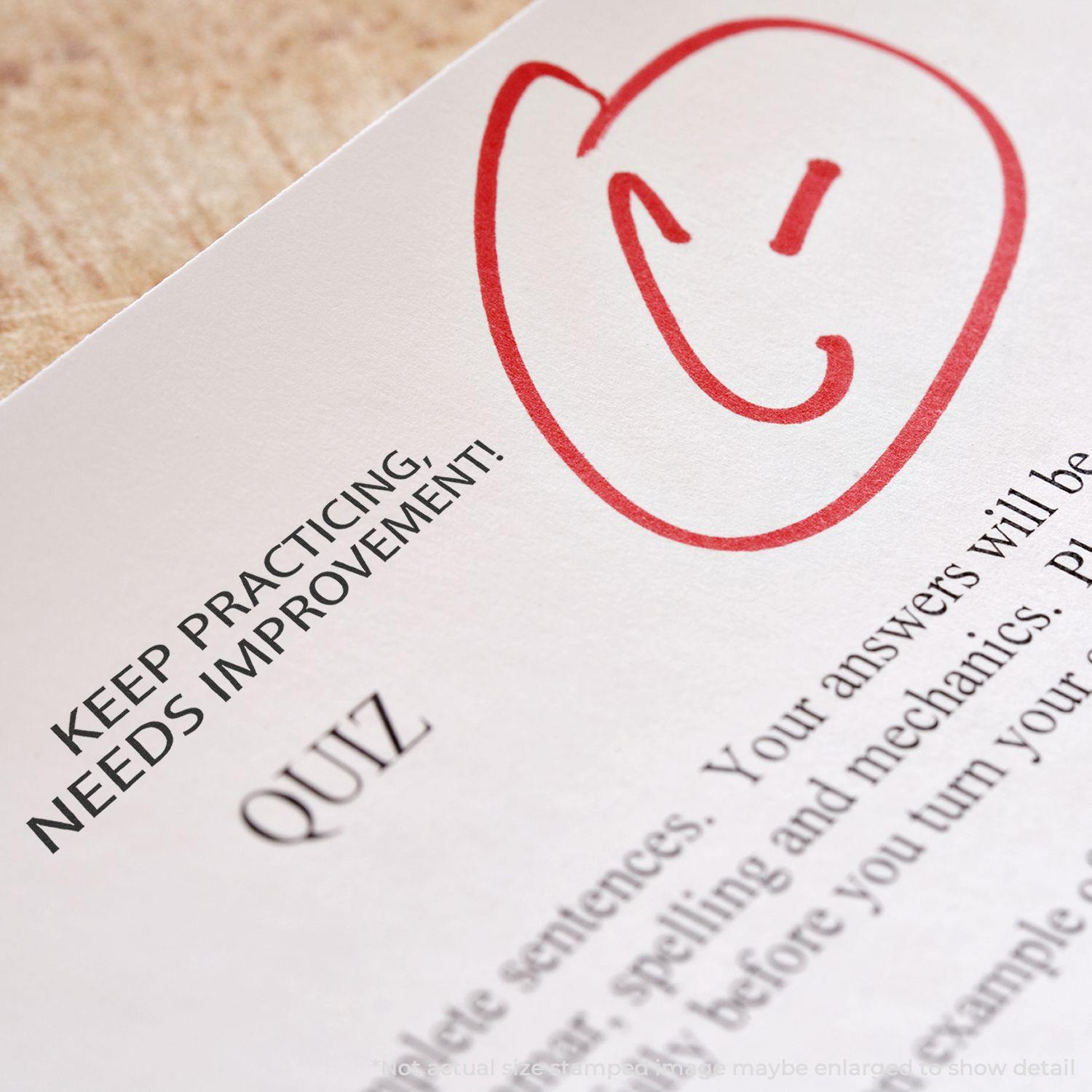 A paper with a red smiley face and the Large Self Inking Needs Improvement Stamp marking KEEP PRACTICING NEEDS IMPROVEMENT! next to a quiz.