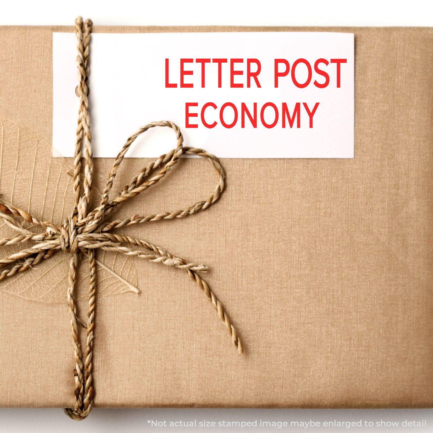 A package wrapped in brown paper with a twine bow, stamped with LETTER POST ECONOMY using the Large Letter Post Economy Rubber Stamp.