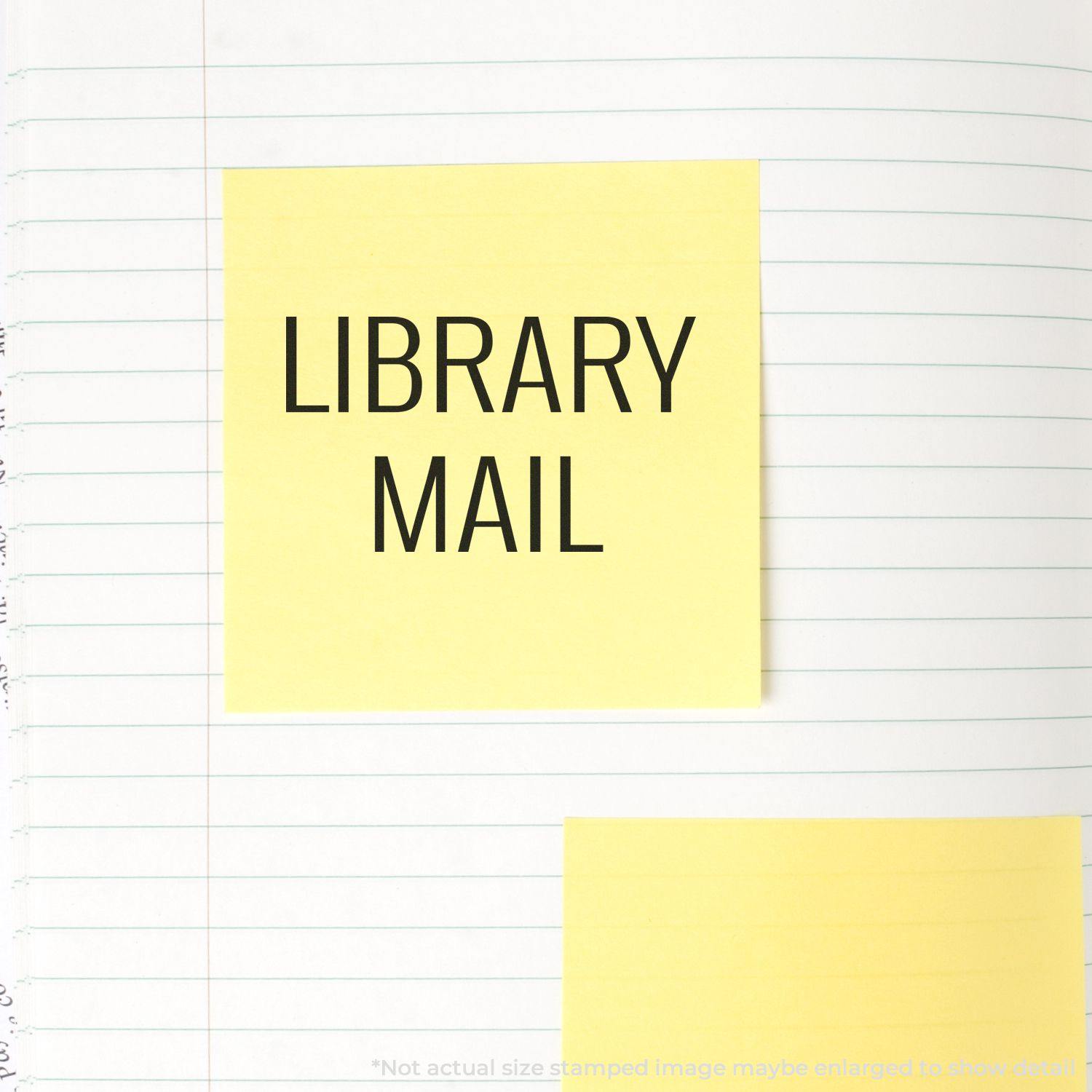 Yellow sticky note with Library Mail stamped on it, placed on a lined notebook page.