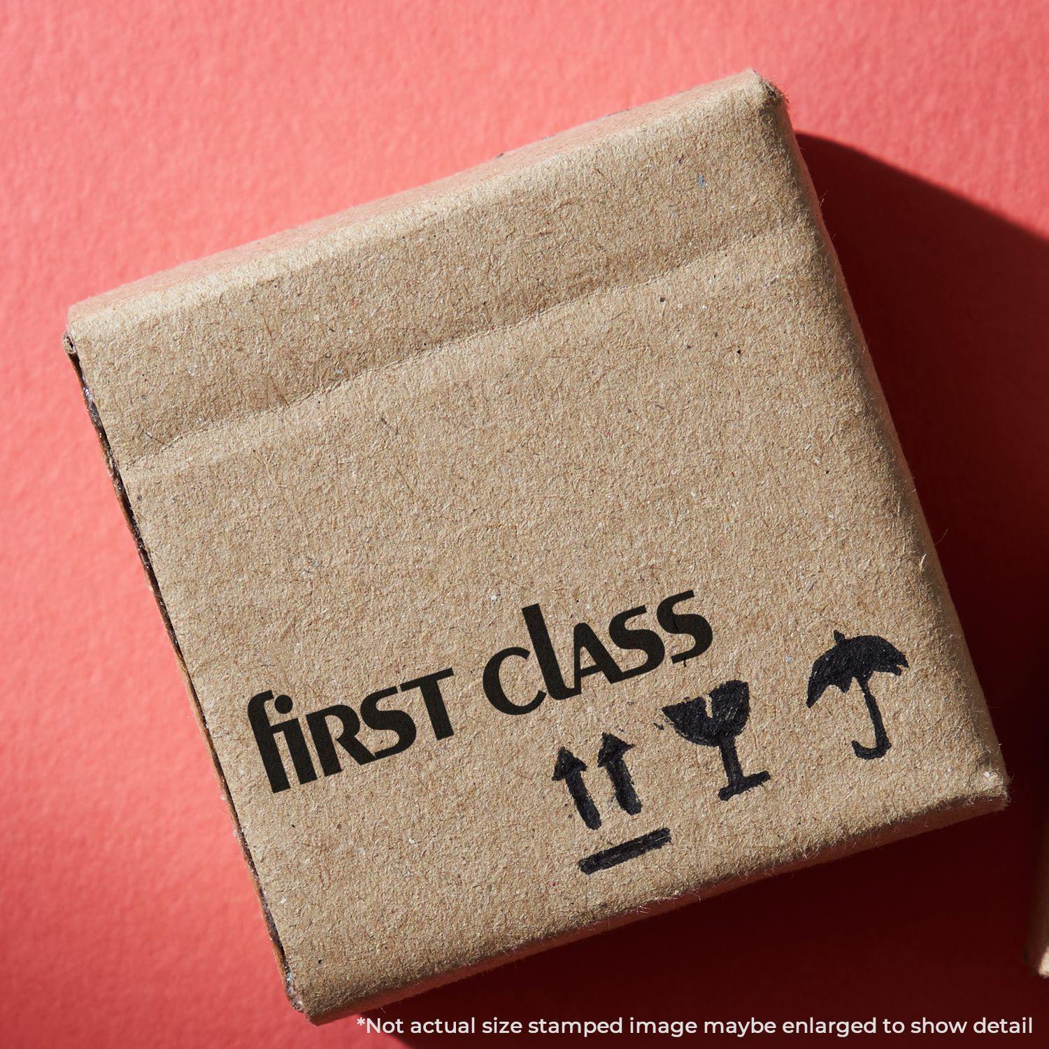 Cardboard box stamped with first class using the Large Self Inking Lower Case First Class Stamp, on a red background.