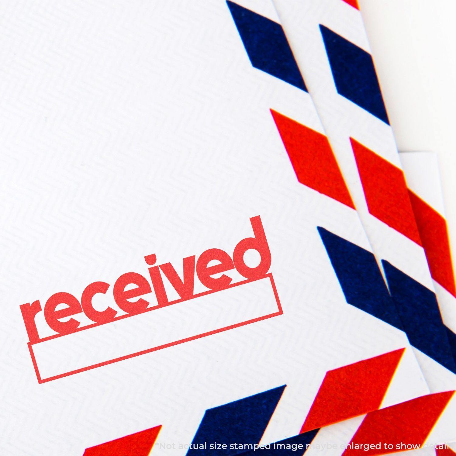 Envelope stamped with received using the Large Pre-Inked Lowercase Received with Date Box Stamp, featuring red and blue chevron design.