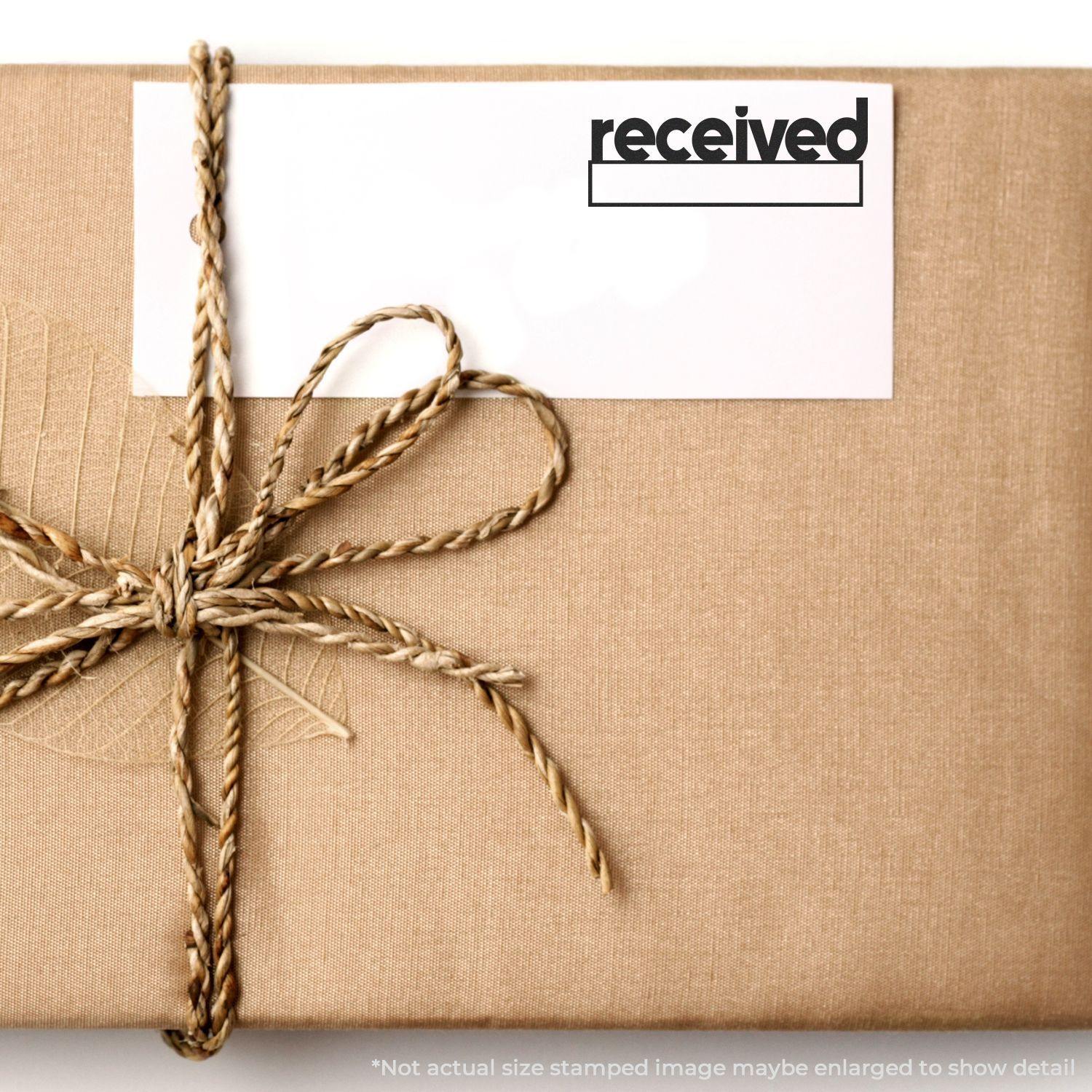 A package wrapped in brown paper with a twine bow, featuring a card stamped with received using the Large Pre-Inked Lowercase Received with Date Box Stamp.