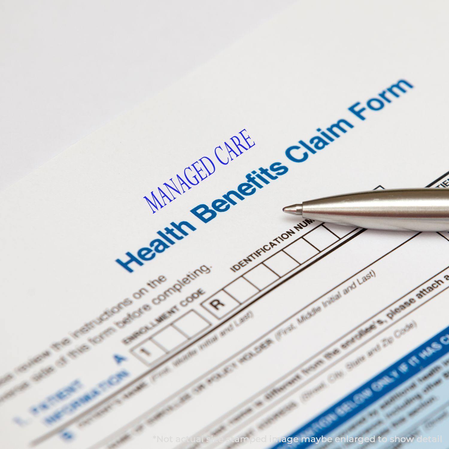 A Large Self Inking Managed Care Stamp is used on a Health Benefits Claim Form, with a pen pointing at the identification number section.