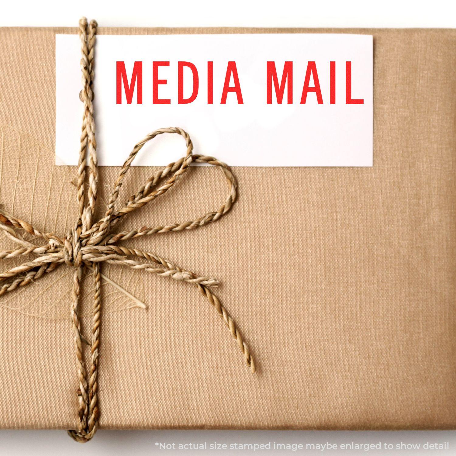 A brown package tied with twine, stamped with MEDIA MAIL using the Large Media Mail Rubber Stamp.