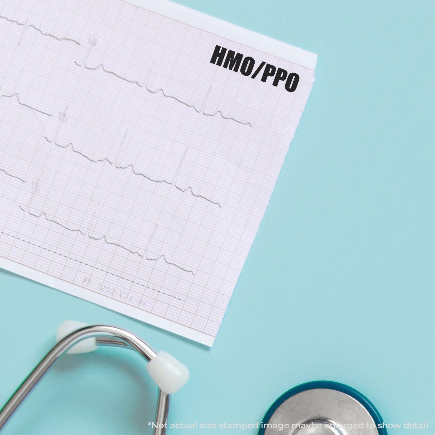 Medical document stamped with HMO/PPO using the Large Pre-Inked HMO/PPO Stamp, placed next to a stethoscope on a light blue surface.