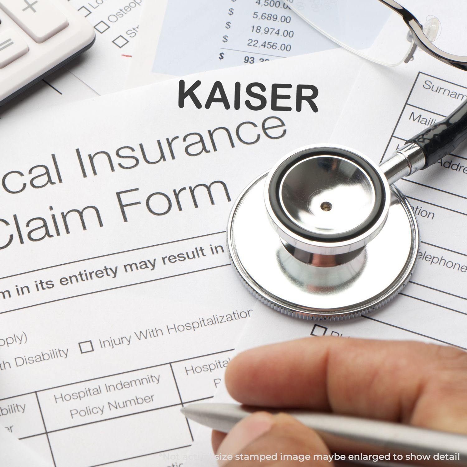 A Large Kaiser Rubber Stamp is used on a medical insurance claim form, with a stethoscope and calculator nearby.