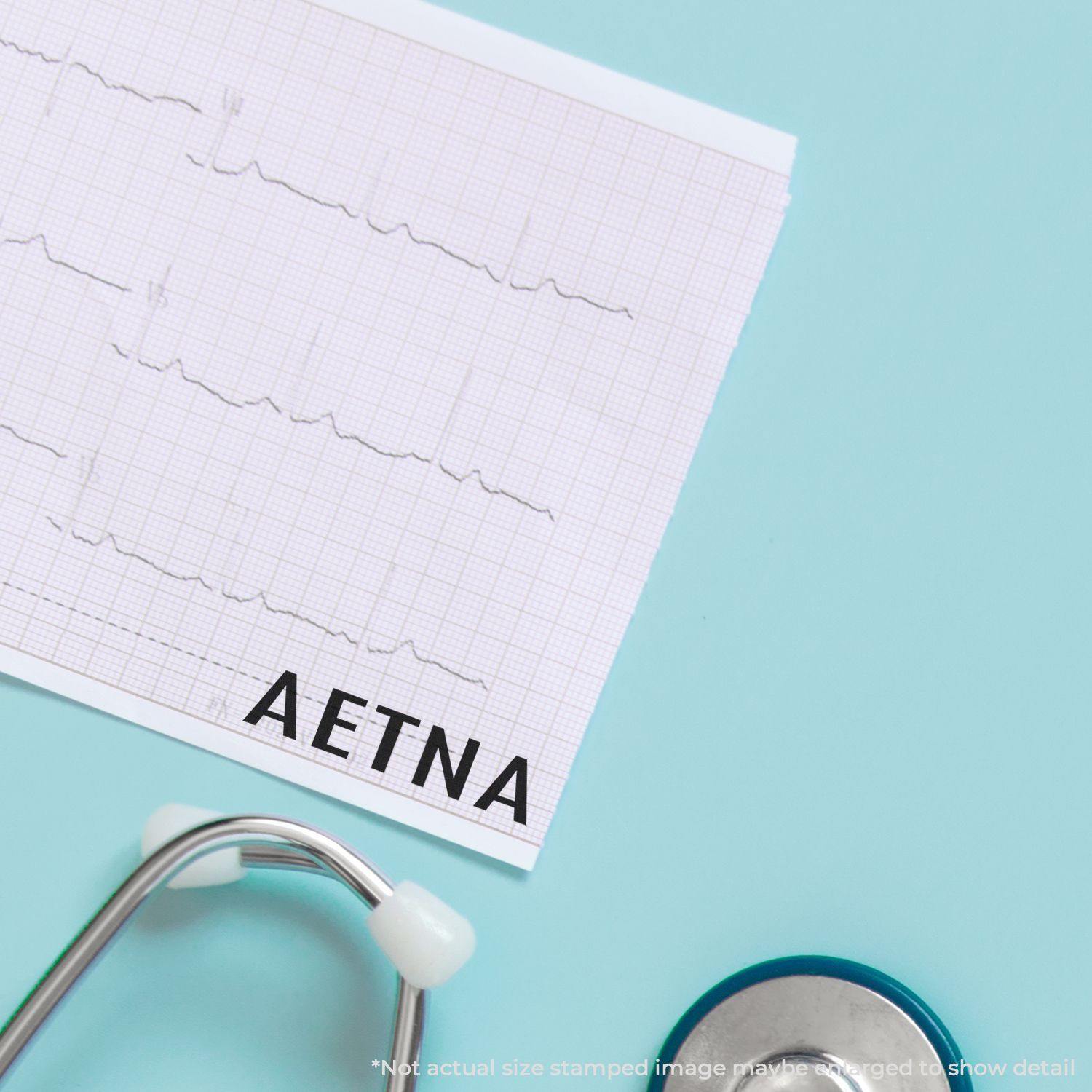 Self Inking Aetna Stamp marking a medical document, with a stethoscope nearby on a light blue background.