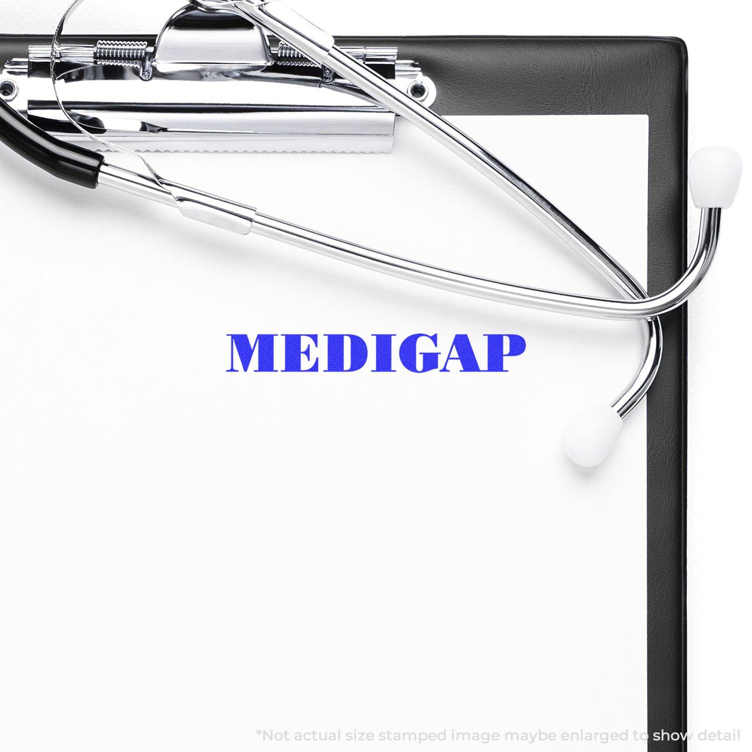 A Large Self Inking Medigap Stamp imprinting the word MEDIGAP in blue ink on a white paper clipped to a black clipboard with a stethoscope.