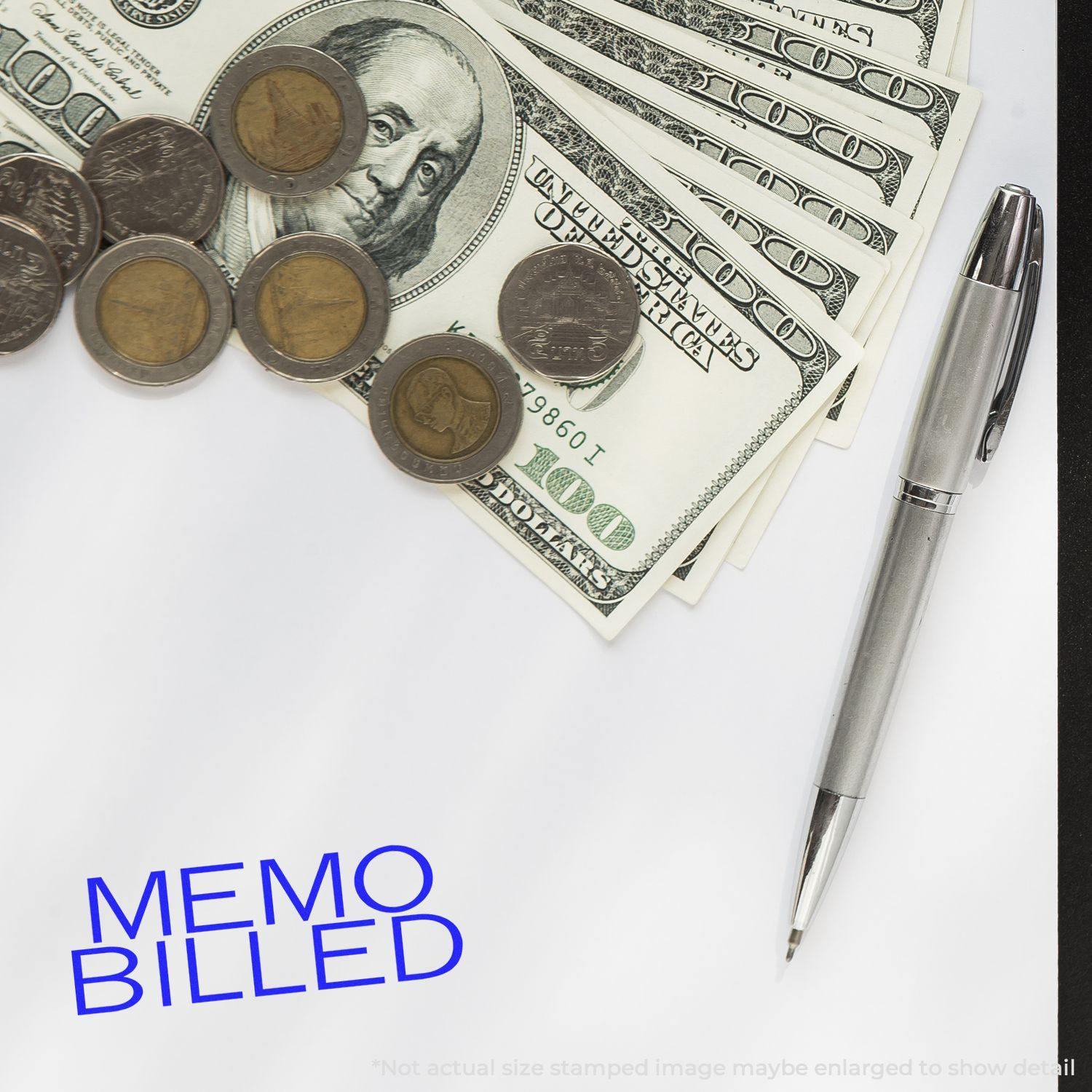 Large Self Inking Memo Billed Stamp used on paper, surrounded by a pen, coins, and dollar bills.