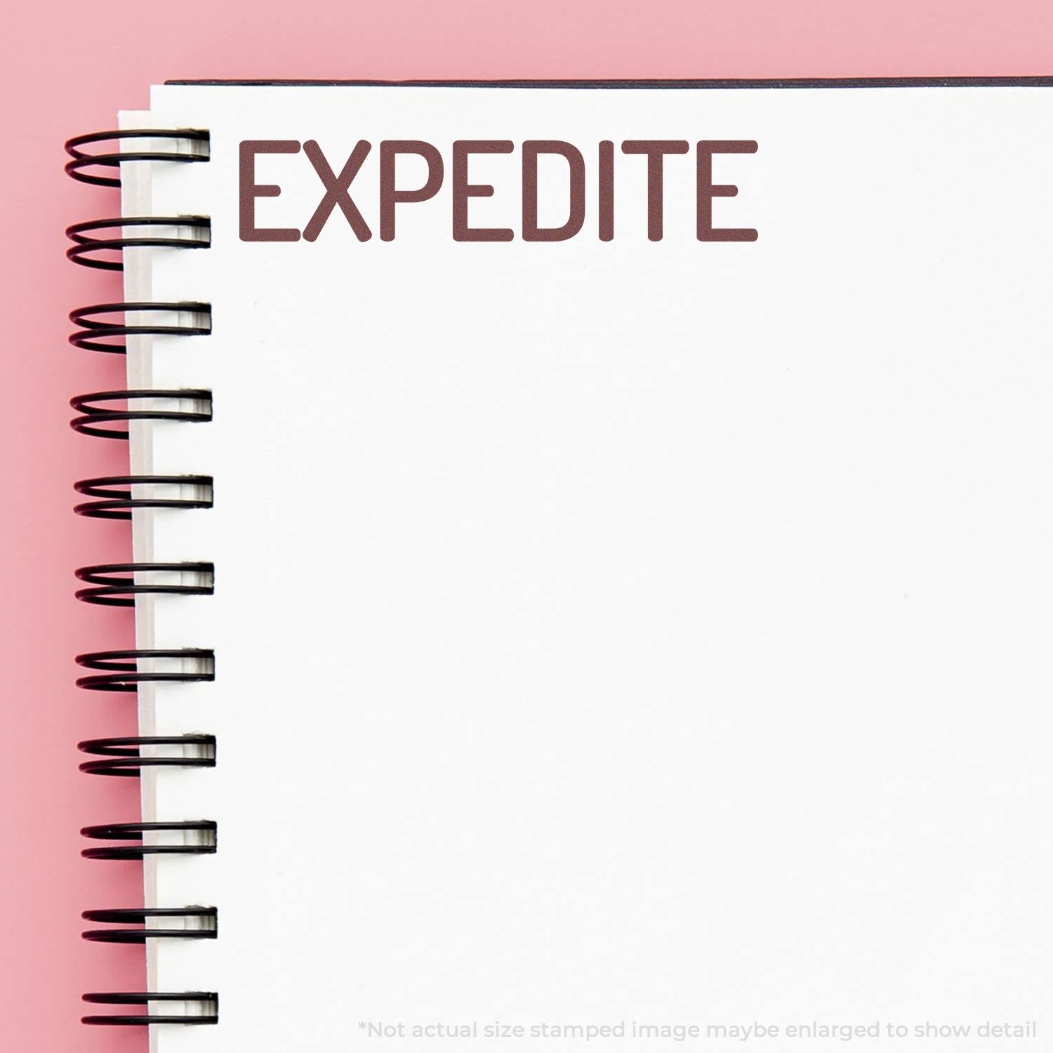 Self Inking Narrow Expedite Stamp marking the word EXPEDITE in bold red ink on the top of a spiral-bound notebook page.