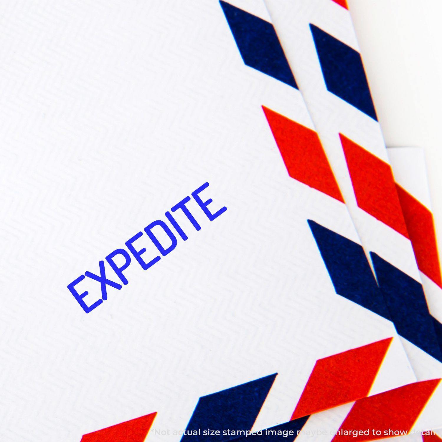 Close-up of an envelope stamped with EXPEDITE using the Large Narrow Expedite Rubber Stamp, featuring red and blue chevron patterns.