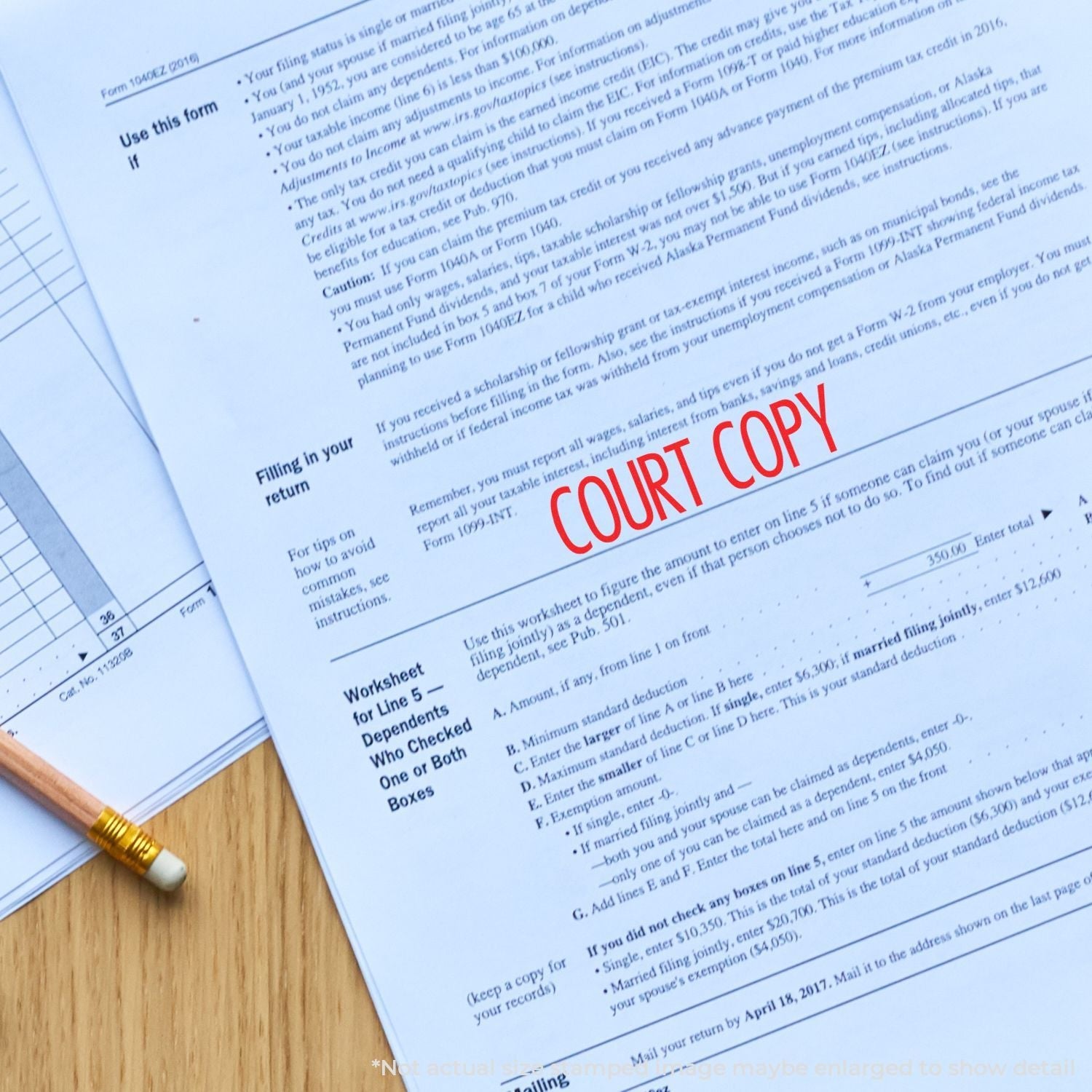 Self Inking Narrow Font Court Copy Stamp in red ink on a document, with a pencil and other paperwork on a wooden surface.