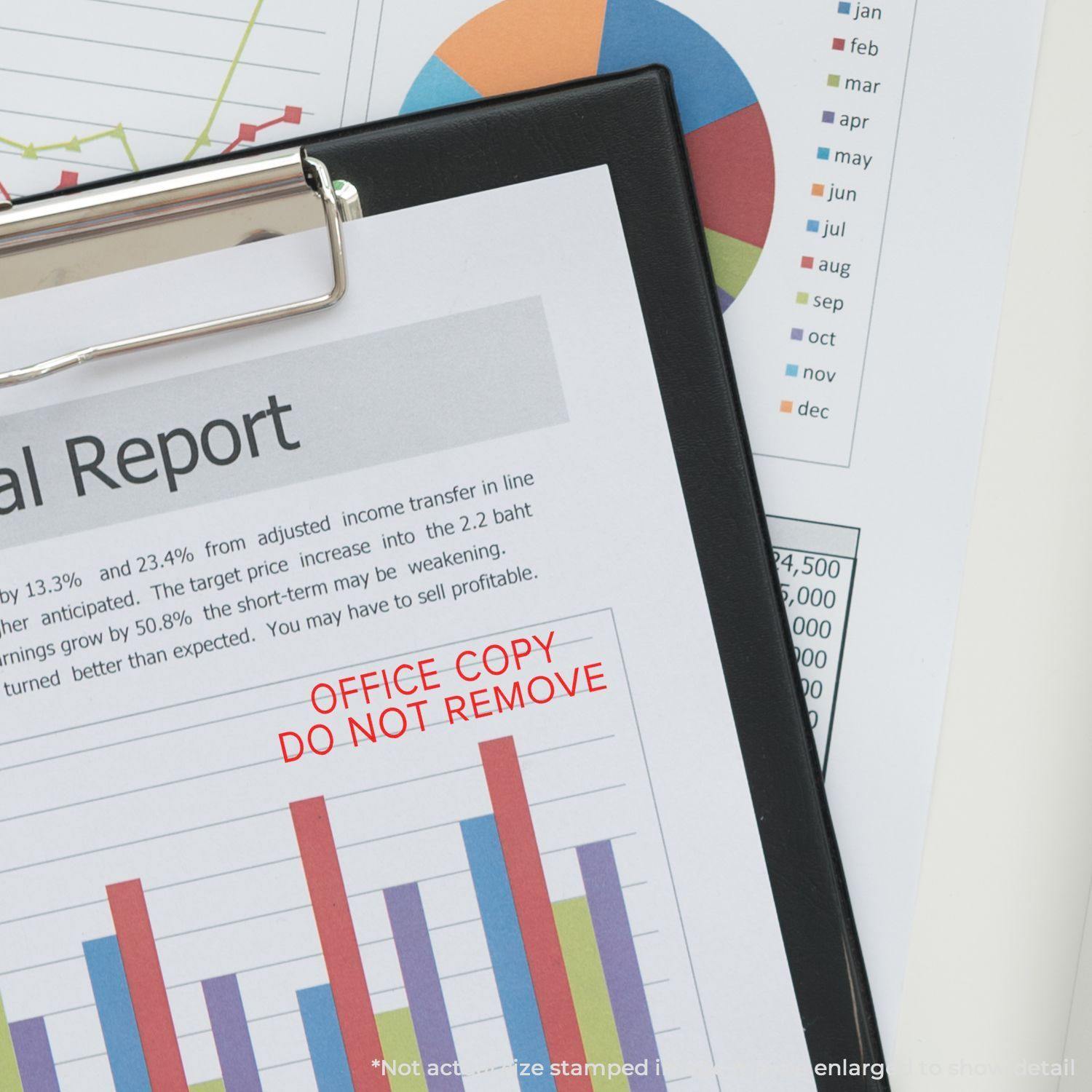 Slim Pre-Inked Narrow Font Office Copy Do Not Remove Stamp on a financial report with charts and graphs in the background.