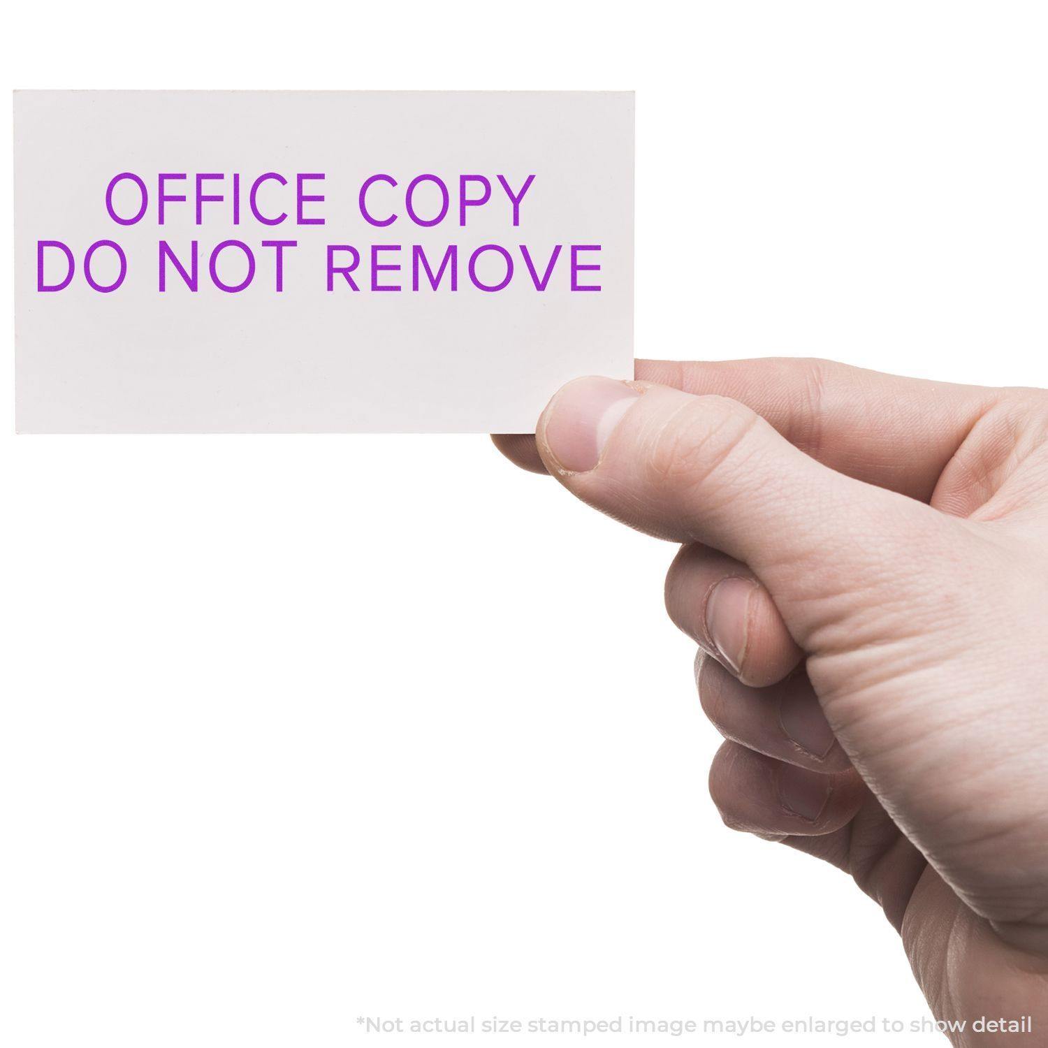 Hand holding a card stamped with OFFICE COPY DO NOT REMOVE using the Large Narrow Font Office Copy Do Not Remove Rubber Stamp.