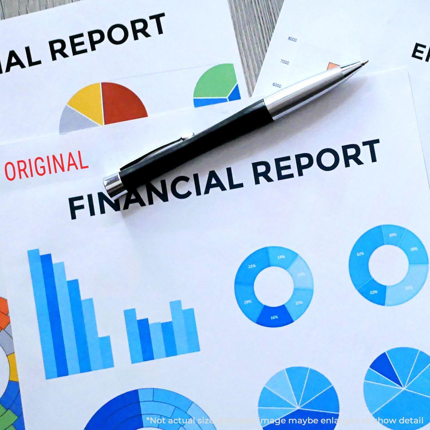 Financial reports stamped with Large Narrow Font Original Rubber Stamp, featuring colorful charts and a pen on a desk.