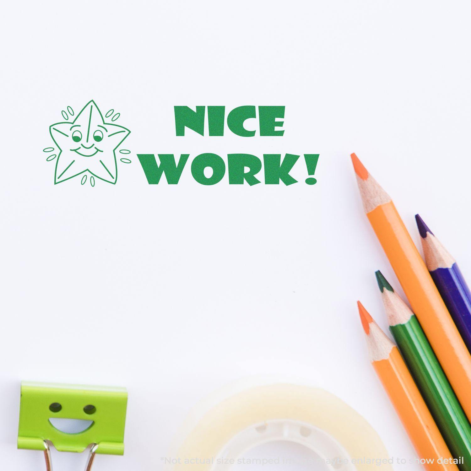 Large Nice Work Rubber Stamp impression on white paper with colorful pencils, a green smiley face clip, and a roll of tape nearby.