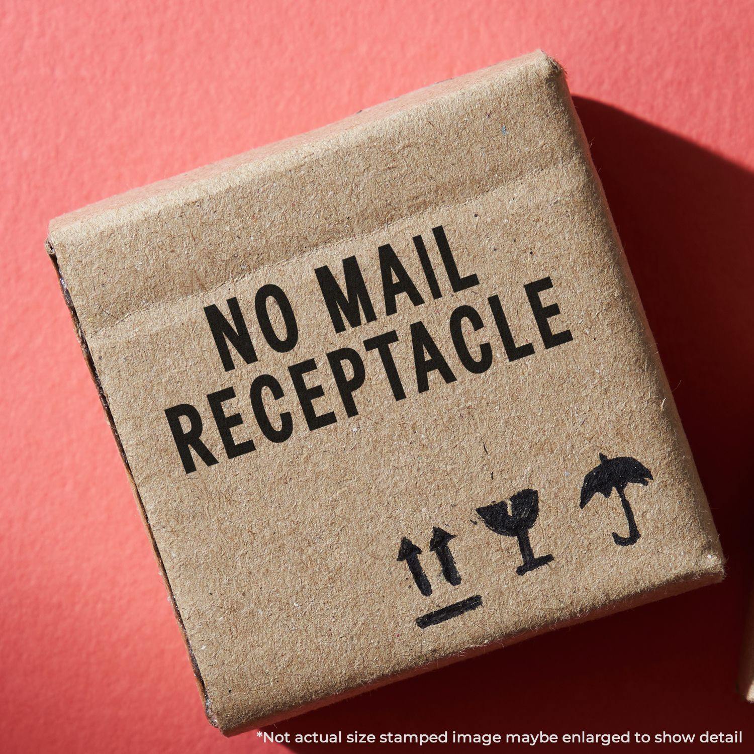 Cardboard box stamped with NO MAIL RECEPTACLE using the Large Pre-Inked No Mail Receptacle Stamp on a red background.