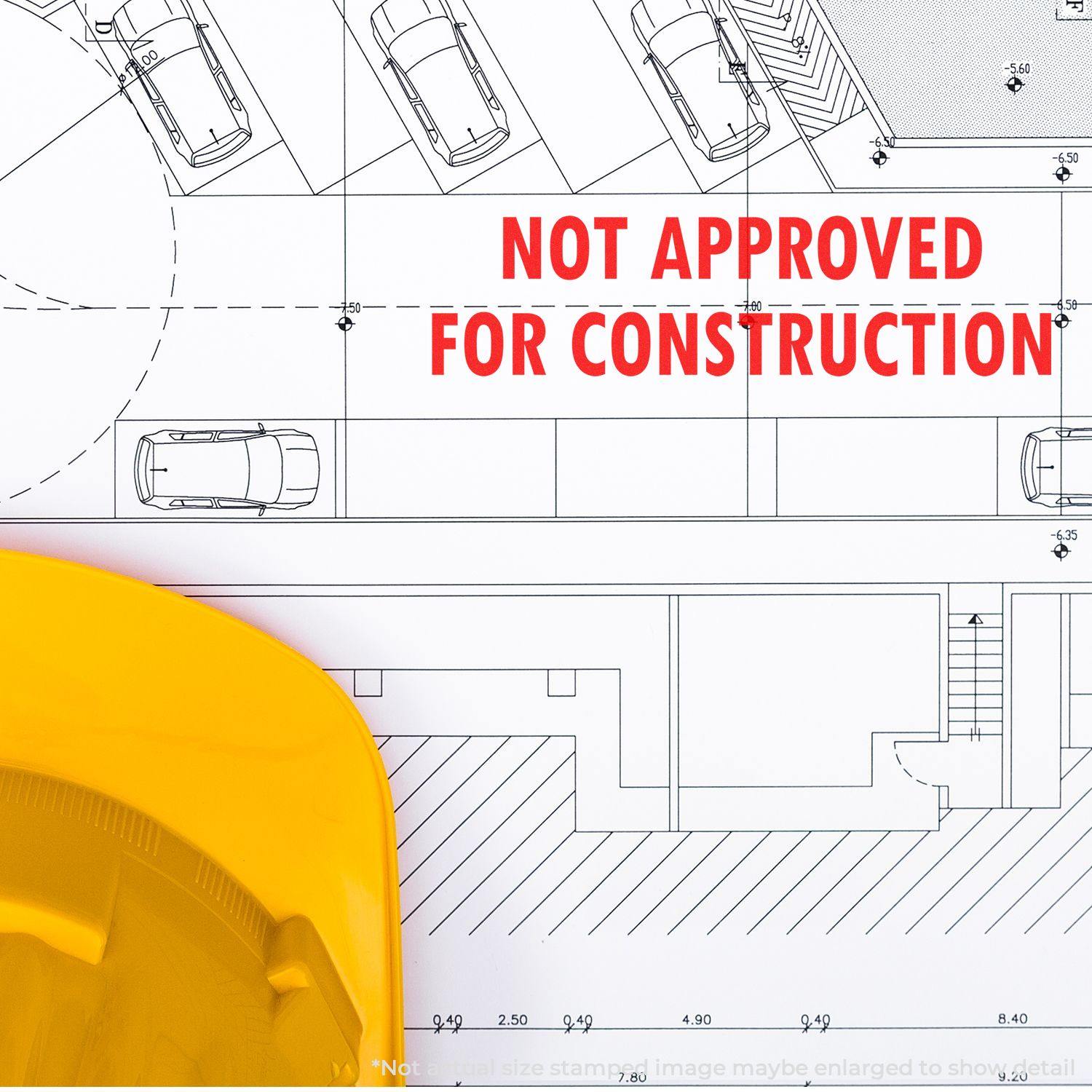 Large Pre-Inked Not Approved For Construction Stamp used on architectural blueprint with a yellow hard hat in the foreground.