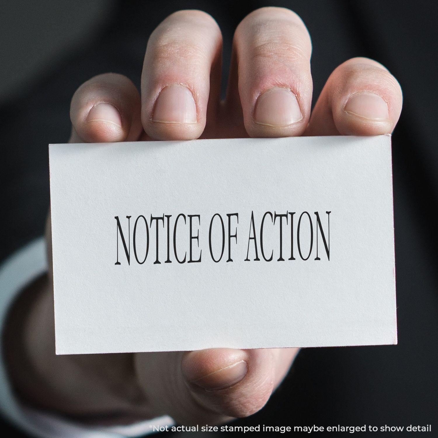 Hand holding a card stamped with NOTICE OF ACTION using the Large Pre-Inked Notice Of Action Stamp.