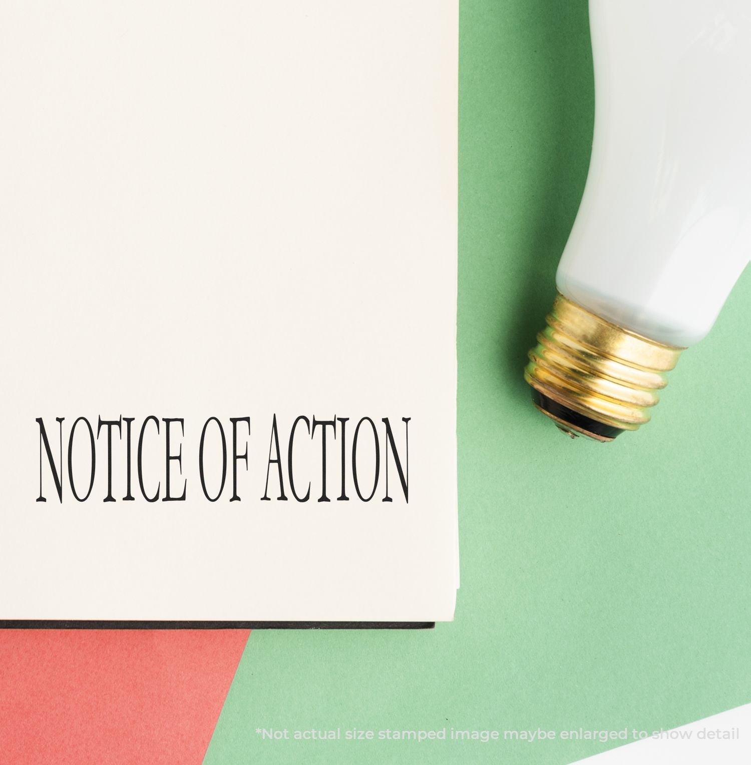 Self Inking Notice Of Action Stamp used on a document, with a light bulb nearby on a colorful background.