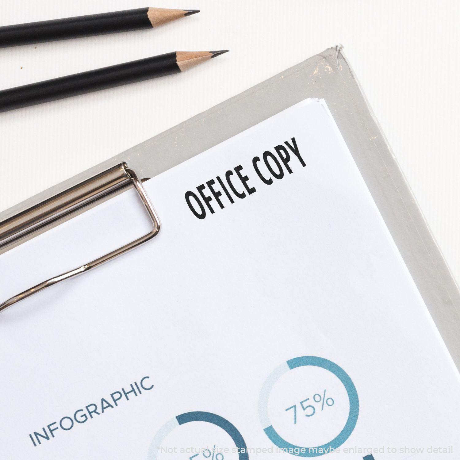 Clipboard with a document stamped OFFICE COPY using the Large Office Copy Rubber Stamp, with two pencils nearby.