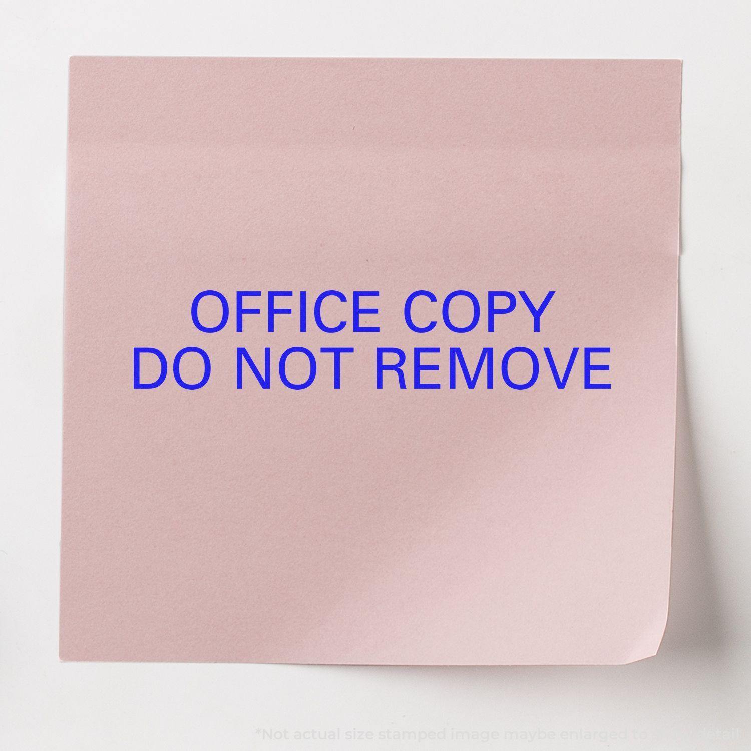 Pink paper stamped with OFFICE COPY DO NOT REMOVE in blue ink using the Large Office Copy Do Not Remove Rubber Stamp.