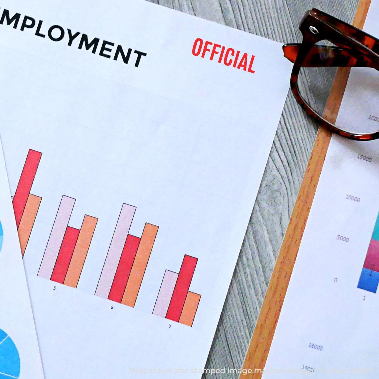 Slim Pre-Inked Official Stamp used on employment document with charts, next to glasses on a wooden surface.