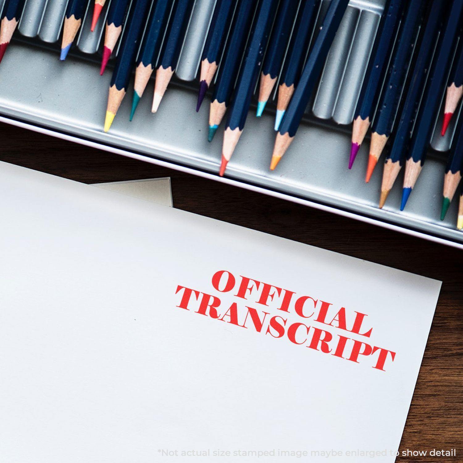 Slim Pre-Inked Official Transcript Stamp in red ink on a white document, with colored pencils in the background.