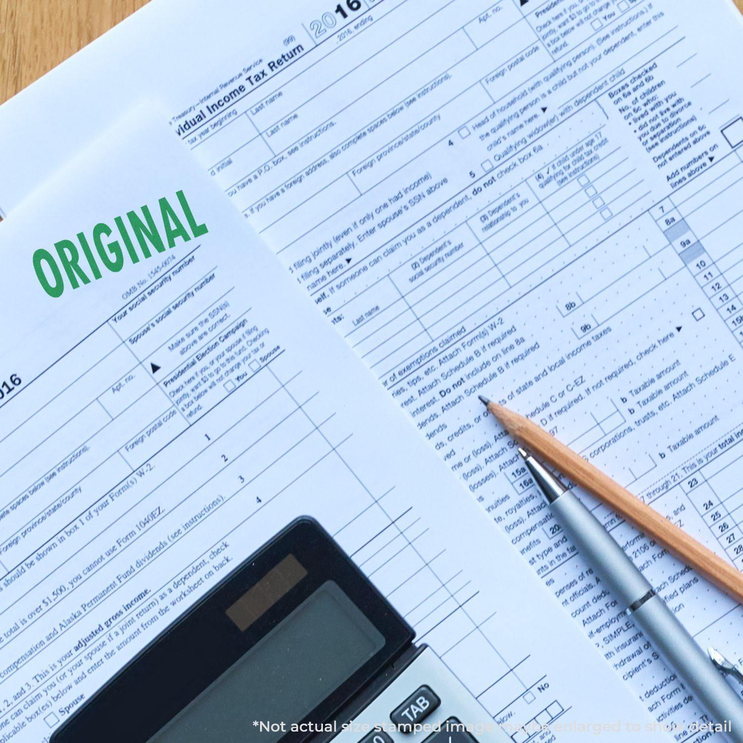 Slim Pre-Inked Original Stamp marking a tax document, accompanied by a pencil, pen, and calculator on a wooden desk.