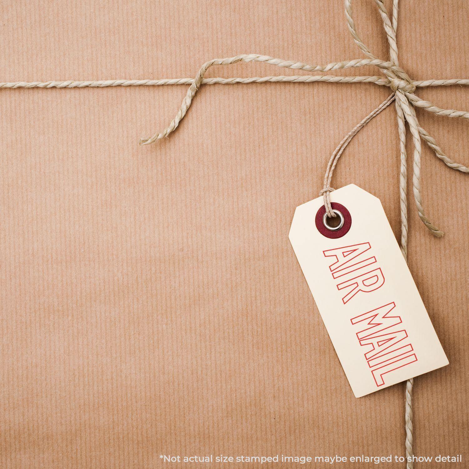 Brown package tied with twine, featuring a tag stamped with AIR MAIL in red, using an Outline Air Mail Rubber Stamp.