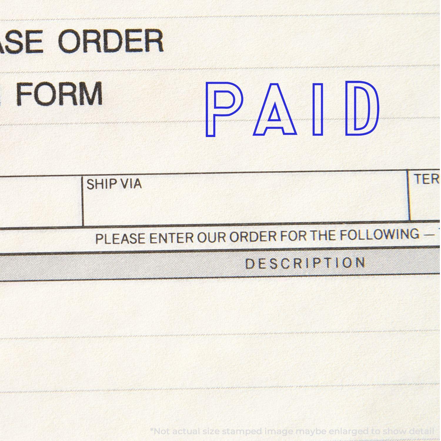 Large Pre-Inked Outline Paid Stamp used on a purchase order form, showing the word PAID in blue ink.