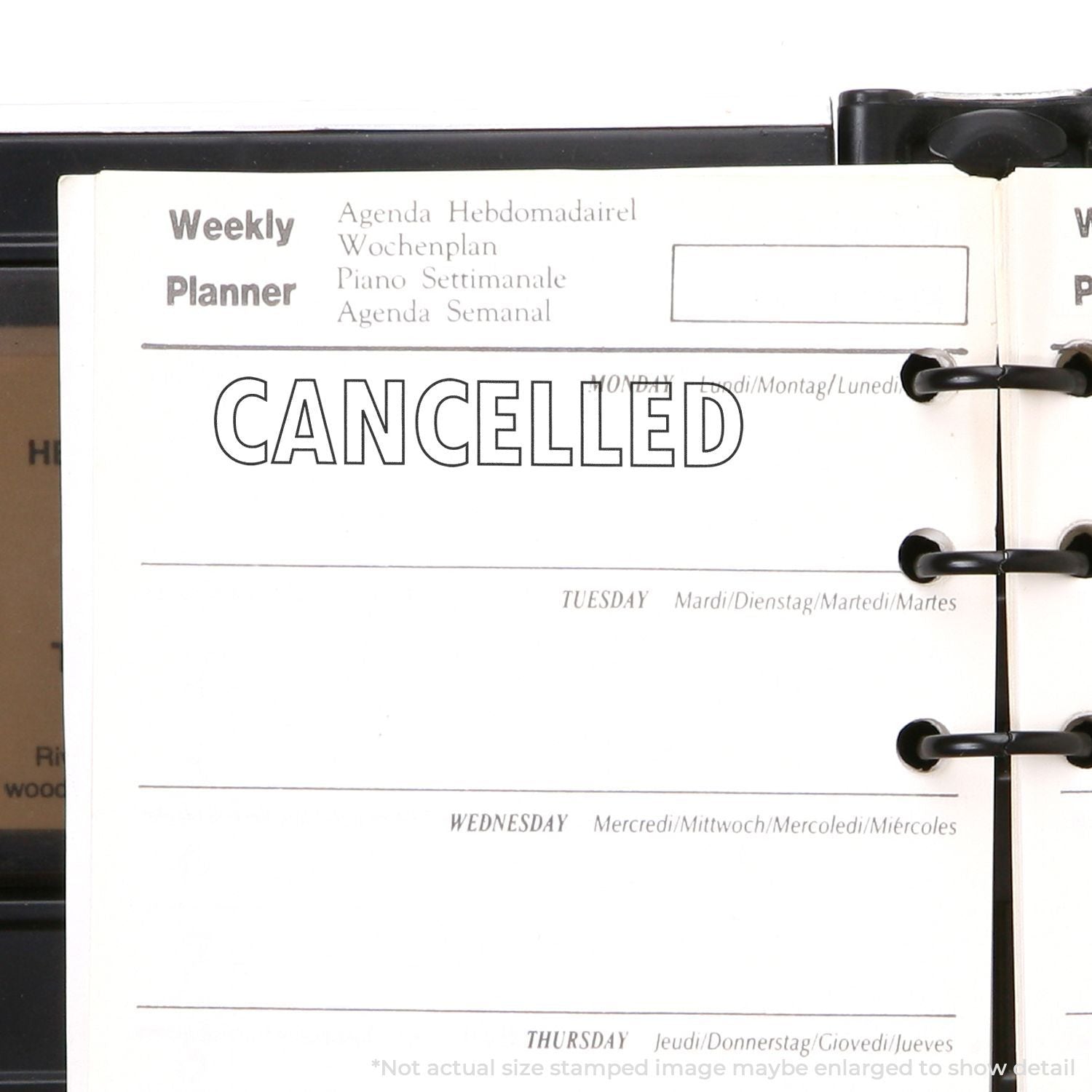 Self Inking Outline Cancelled Stamp used on a weekly planner, showing the word CANCELLED stamped in bold outline font on a Monday.