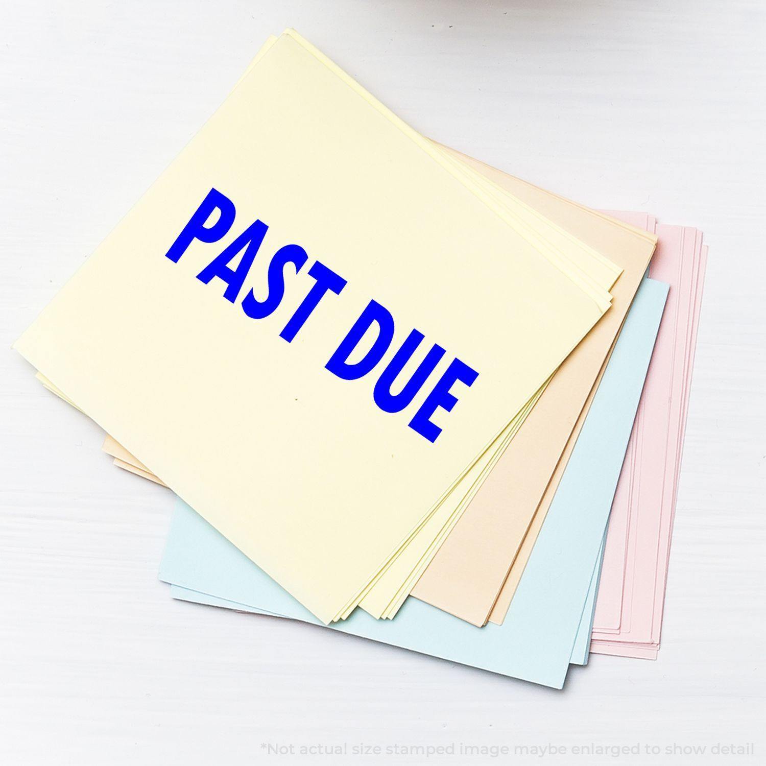 A stack of pastel-colored papers stamped with PAST DUE in blue ink using the Large Past Due Rubber Stamp.