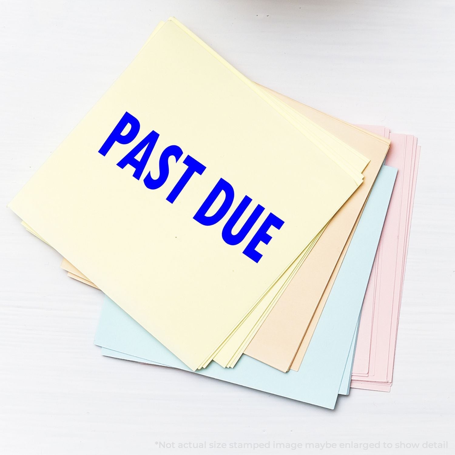 A stack of pastel-colored papers with PAST DUE stamped in blue using the Self Inking Past Due Stamp, placed on a white surface.