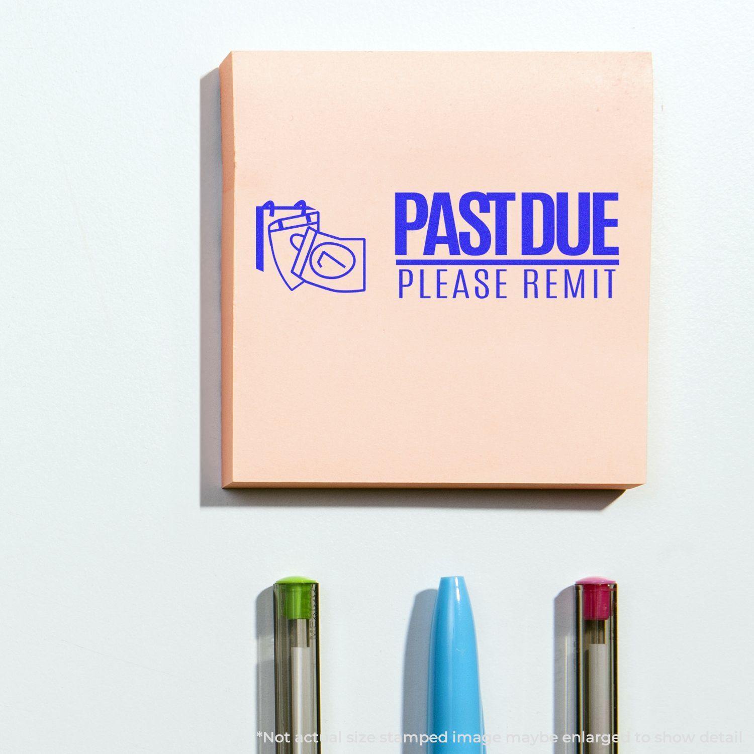 Past Due Please Remit rubber stamp on a pink sticky note with a calendar icon, placed above three pens on a white surface.