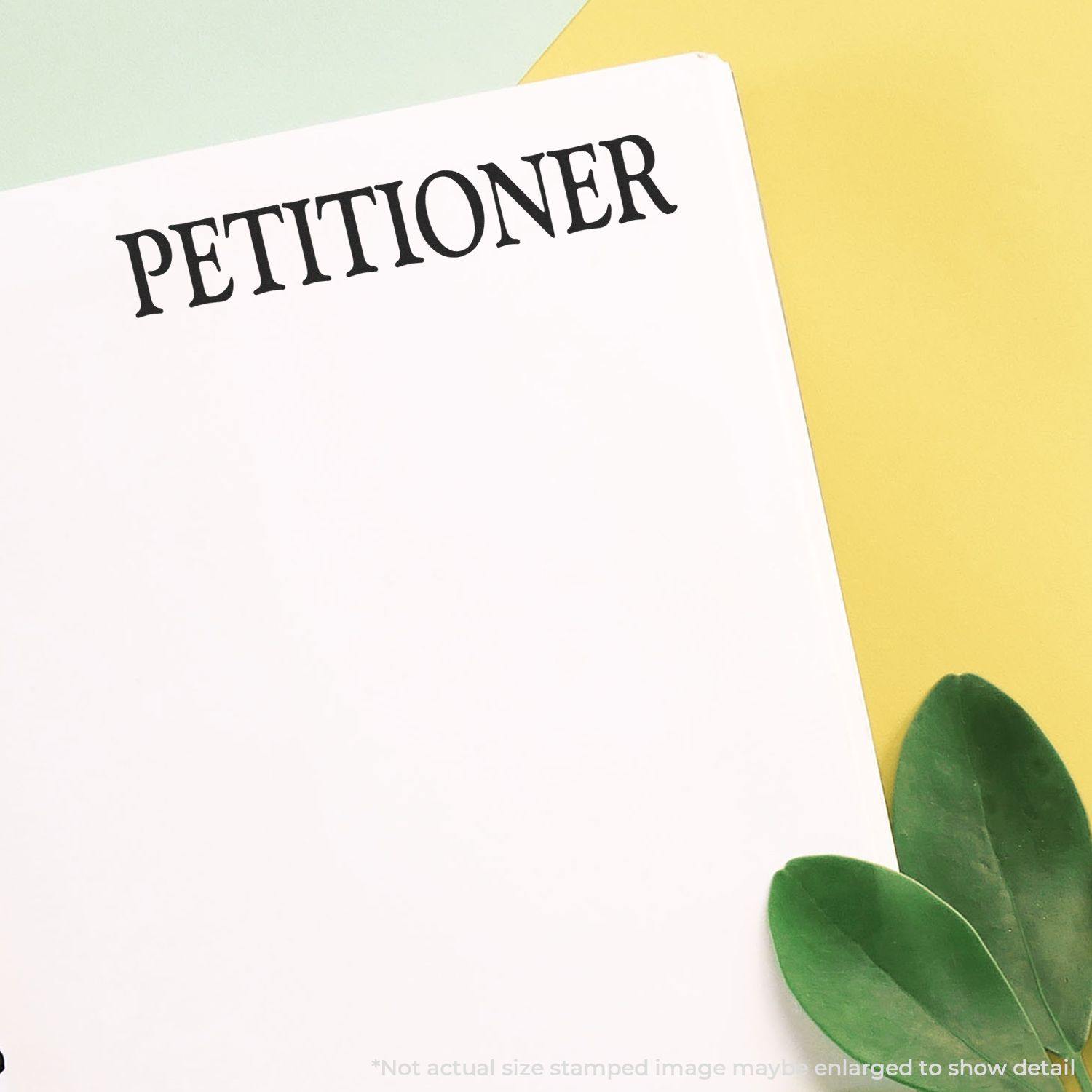 Petitioner Rubber Stamp impression on white paper with green leaves and yellow background.