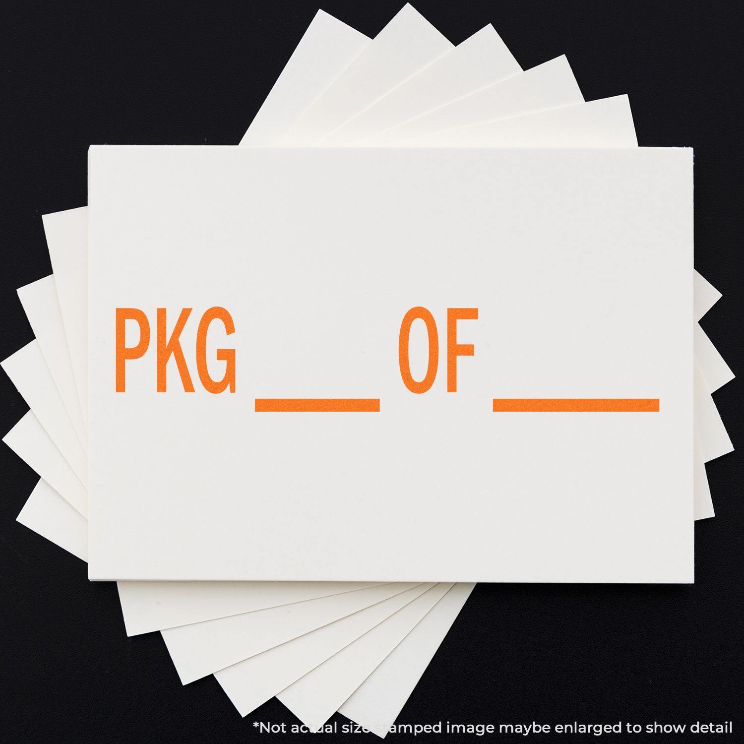 Large Pkg Rubber Stamp in use, stamping PKG OF in orange on white cards, arranged in a fan shape on a black background.