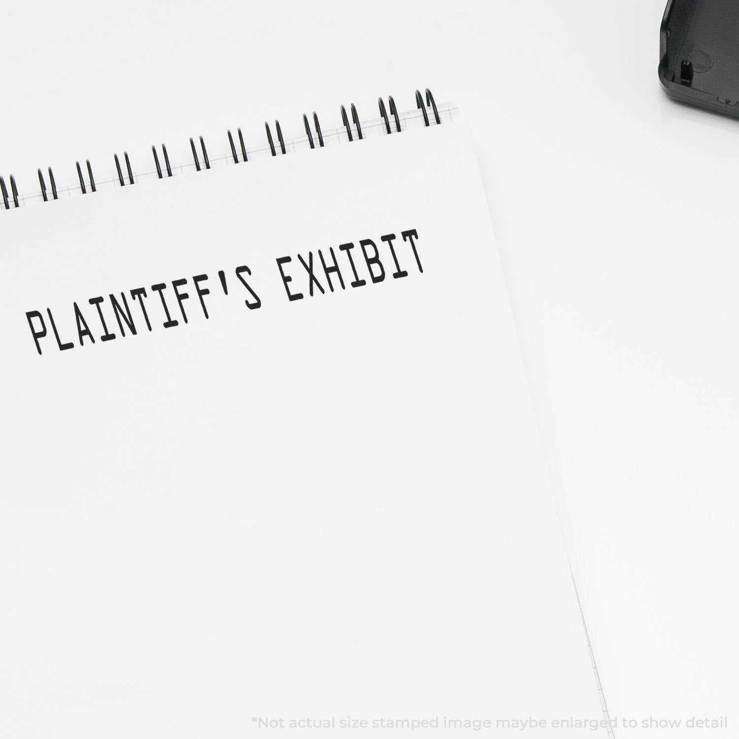 Slim Pre-Inked Plaintiff's Exhibit Stamp used on a white notepad, displaying the text 'PLAINTIFF'S EXHIBIT' in black ink.