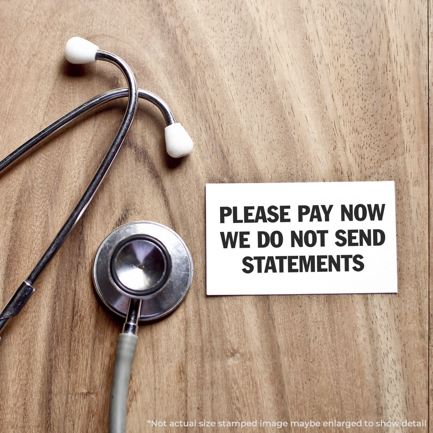 A stethoscope on a wooden surface next to a card stamped with PLEASE PAY NOW WE DO NOT SEND STATEMENTS using the Self Inking Please Pay Now No Statements Stamp.