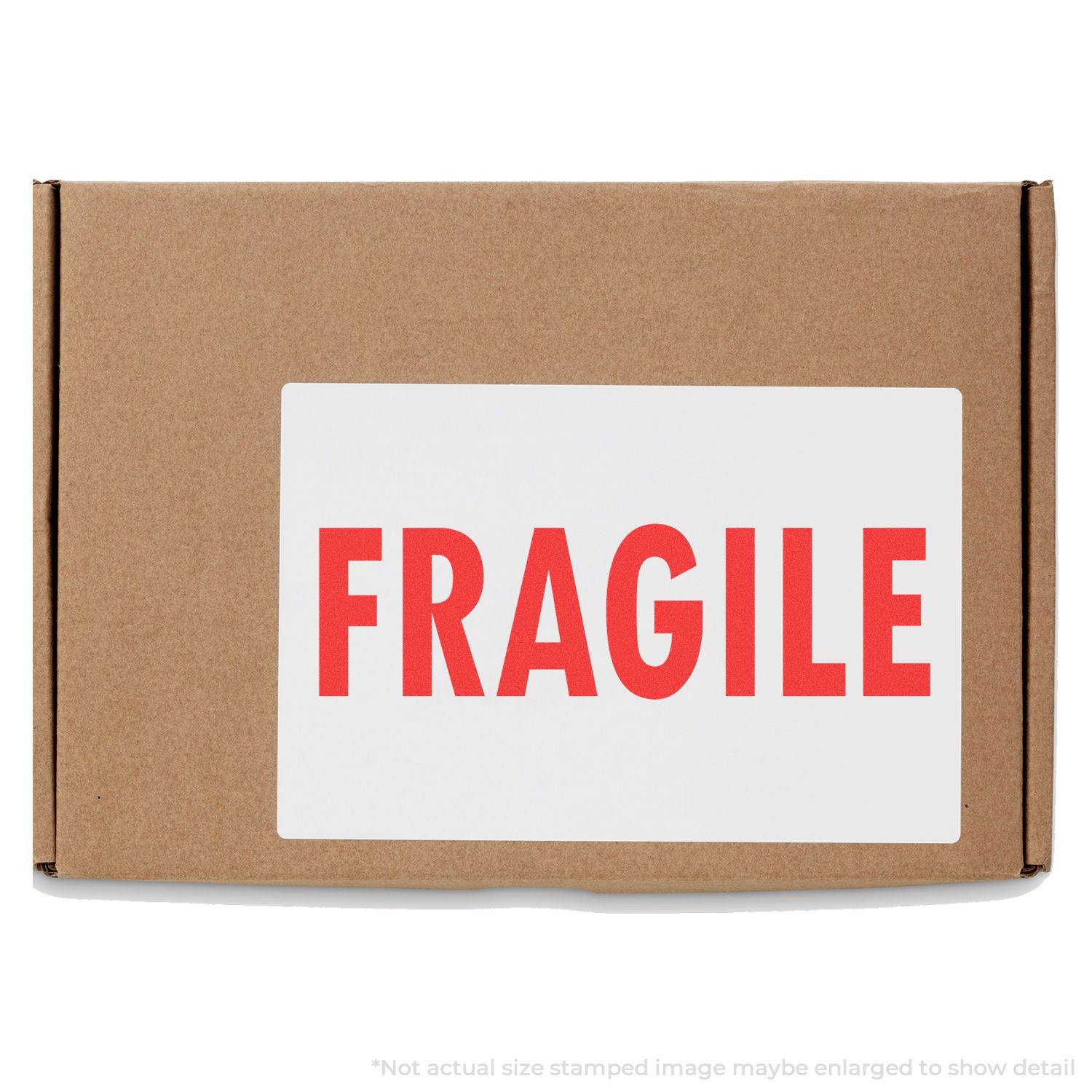 Large Self Inking Fragile Stamp used on a brown cardboard box, displaying the word FRAGILE in bold red letters on a white label.