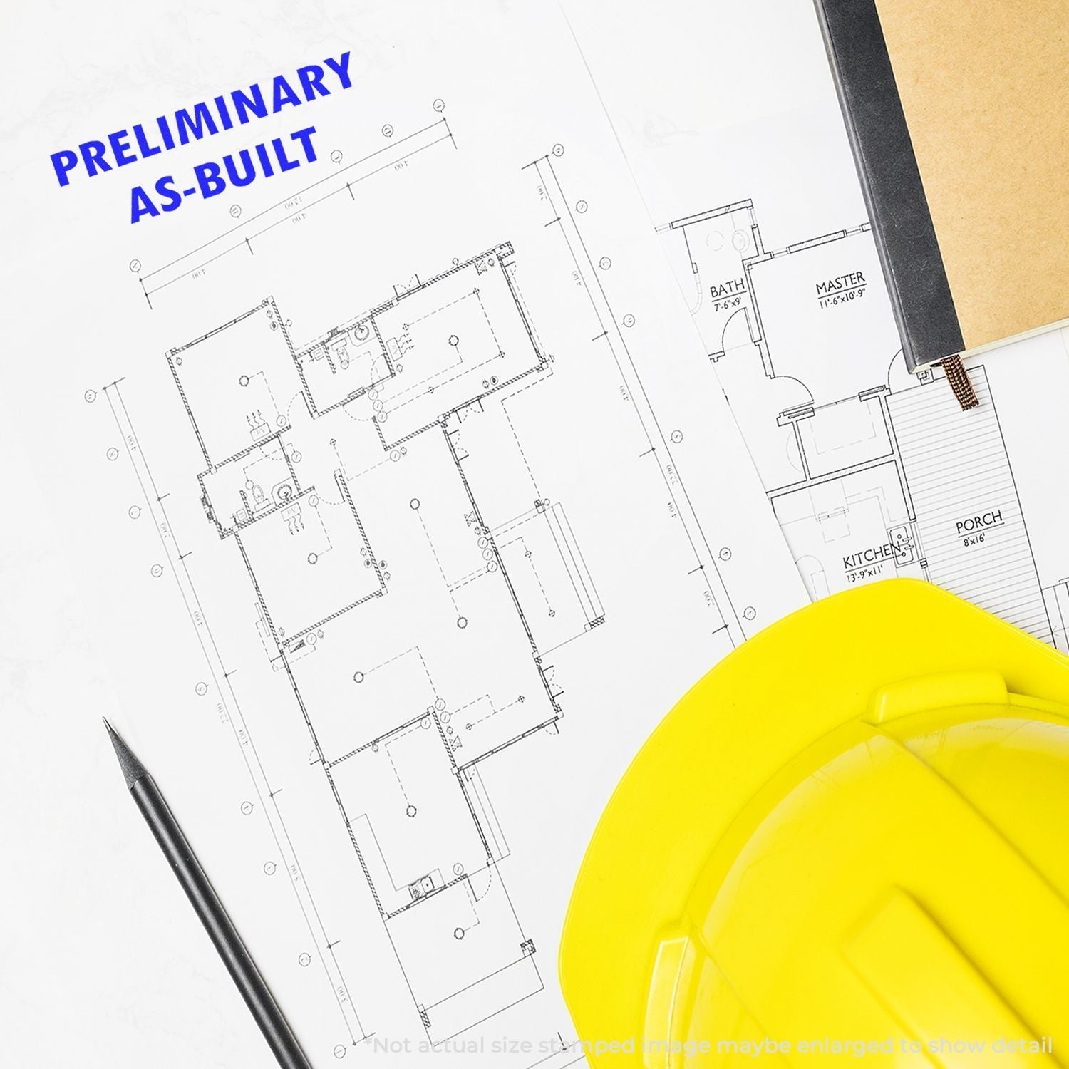 A Self Inking Preliminary As Built Stamp is used on a blueprint next to a yellow hard hat and a black pen.