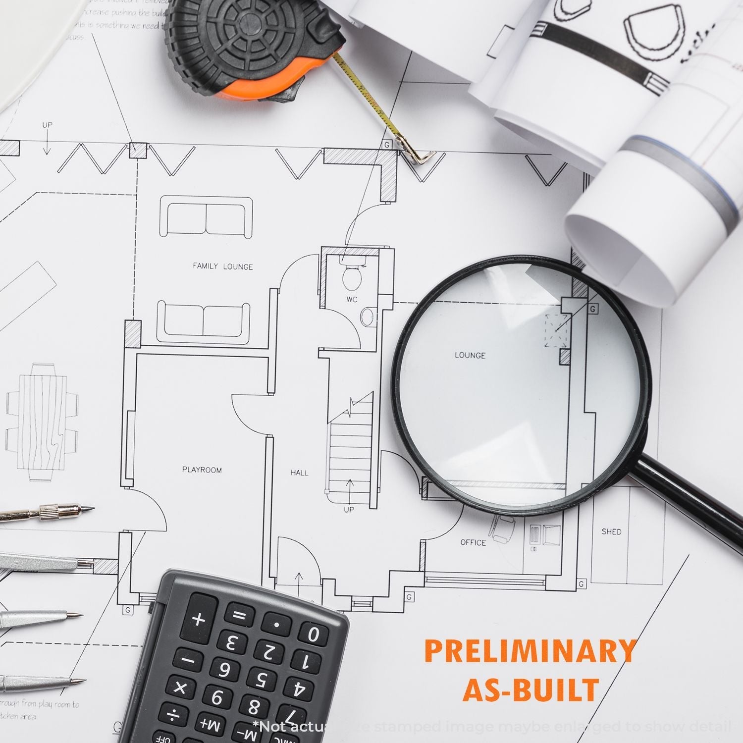 A Self Inking Preliminary As Built Stamp is shown on a detailed architectural blueprint with a magnifying glass, calculator, and measuring tape.