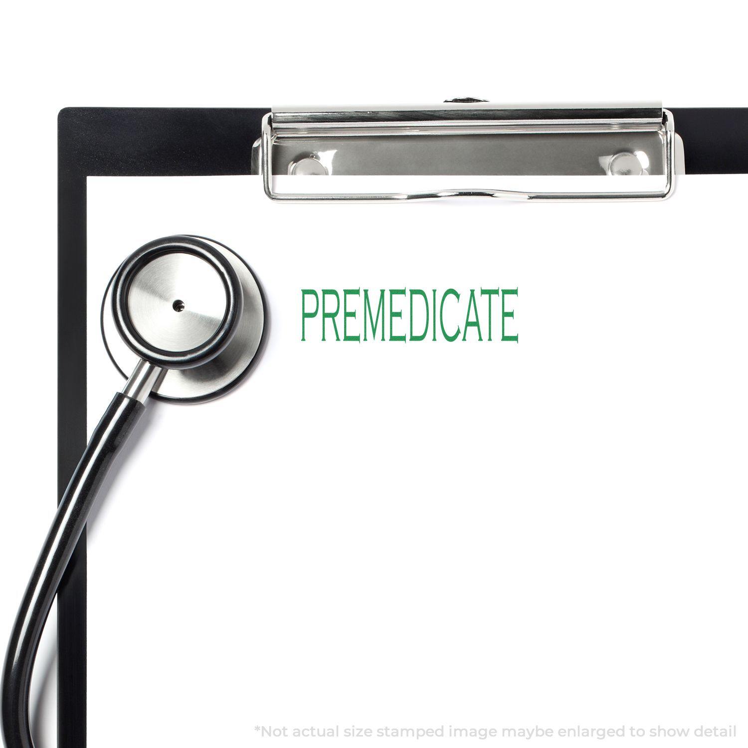 Slim Pre-Inked Premedicate Stamp used on a clipboard with a stethoscope beside it, displaying the word PREMEDICATE in green.