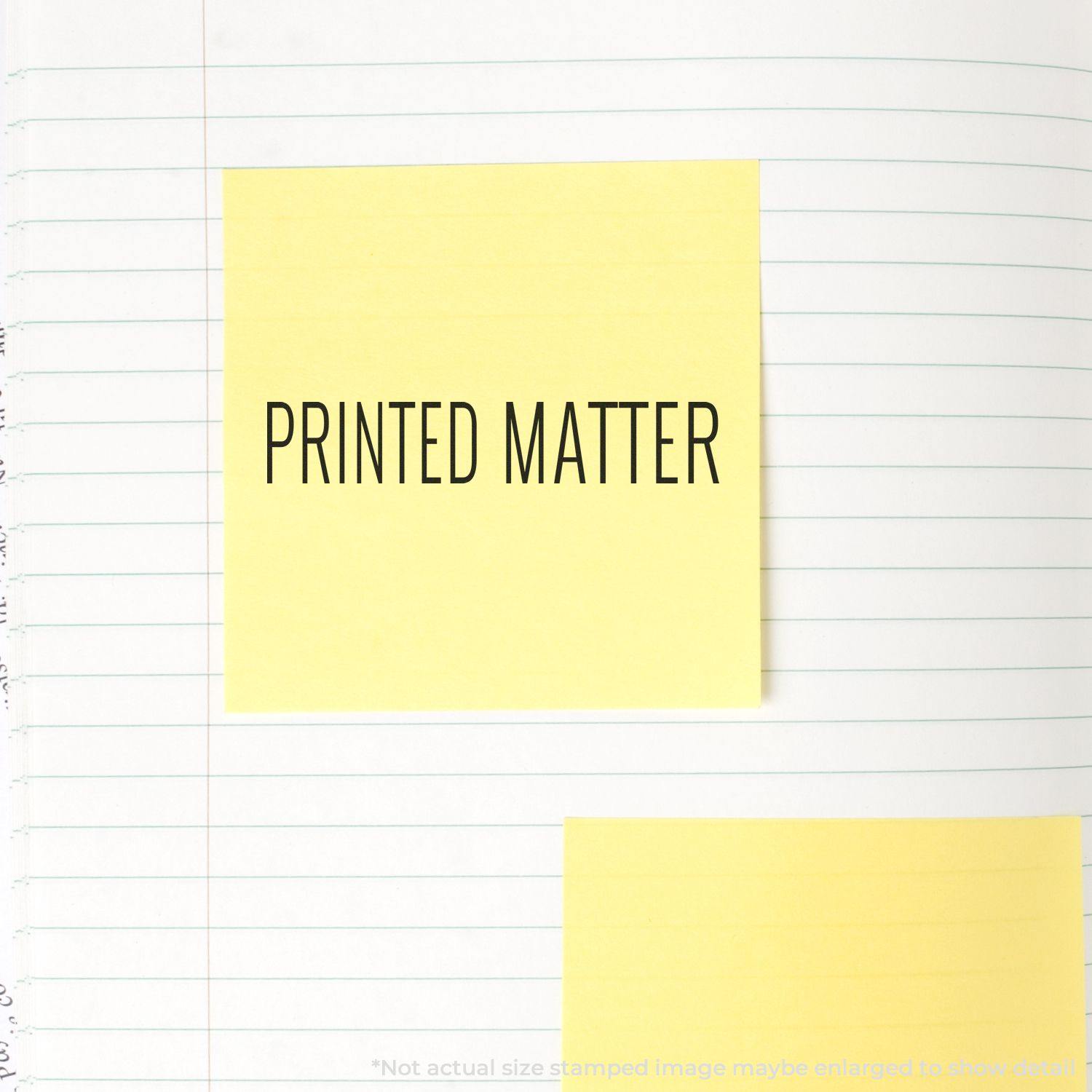 Large Self Inking Printed Matter Stamp used on a yellow sticky note placed on a lined notebook page.