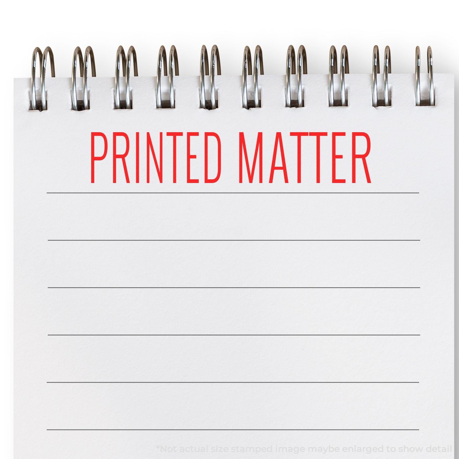 A notebook with PRINTED MATTER stamped in red using a Self Inking Printed Matter Stamp, with metal spiral binding at the top.